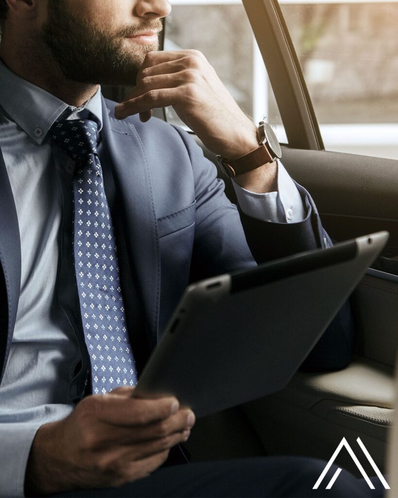 Businessman using tablet in car